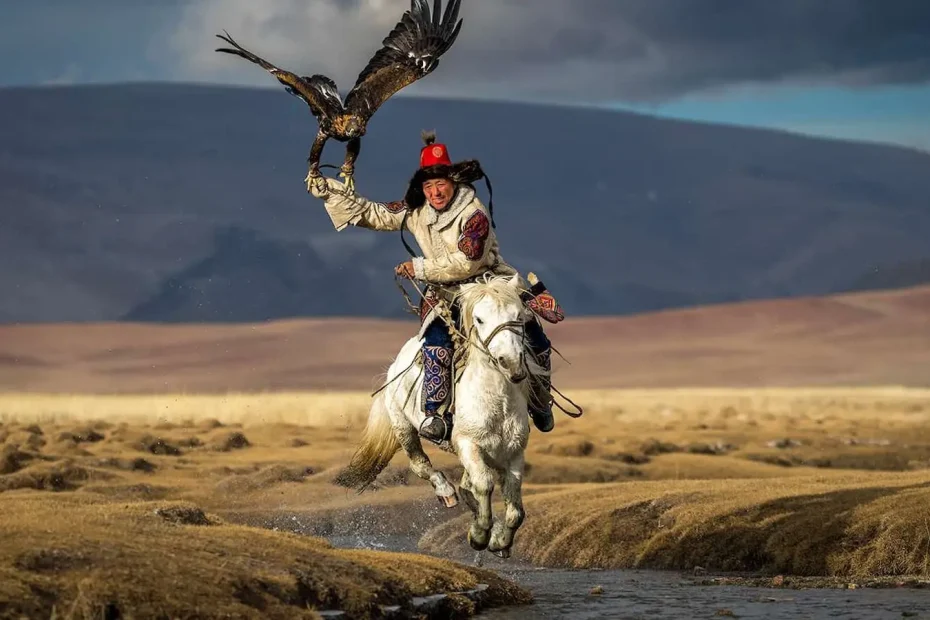 Mongolian man on a horse holding an eagle