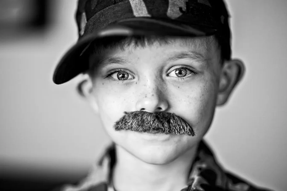 a black and white photo of a boy wearing a moustache with a baseball cap EU Funding & Me